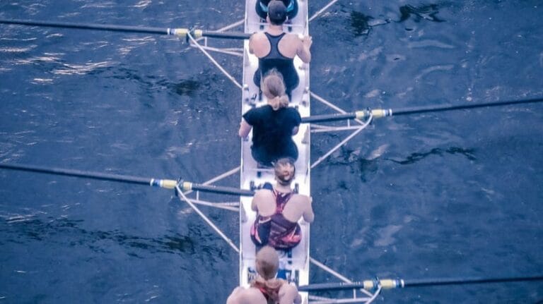 Equipe féminine faisant de l'aviron pour illustrer l'article sur Ancrer l'apprentissage dans la réalité : un changement de comportement durable pour les équipes réelles