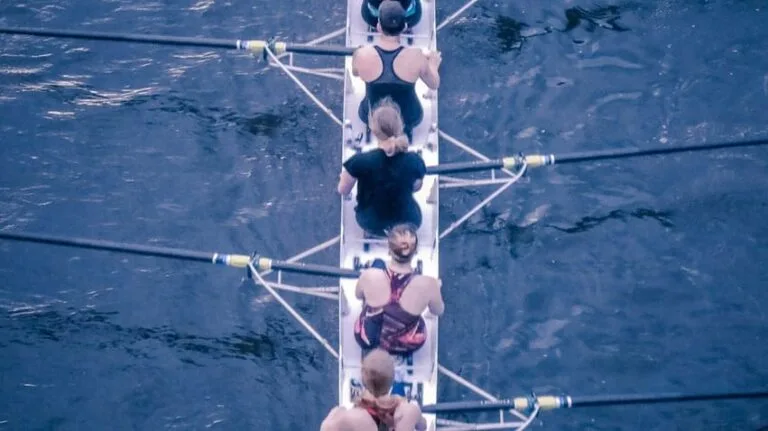 Equipe féminine faisant de l'aviron pour illustrer l'article sur Ancrer l'apprentissage dans la réalité : un changement de comportement durable pour les équipes réelles