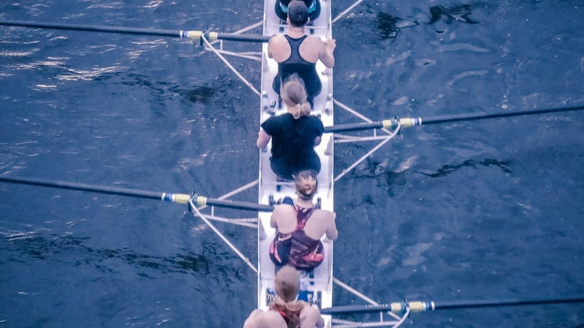 Equipe féminine faisant de l'aviron pour illustrer l'article sur Ancrer l'apprentissage dans la réalité : un changement de comportement durable pour les équipes réelles