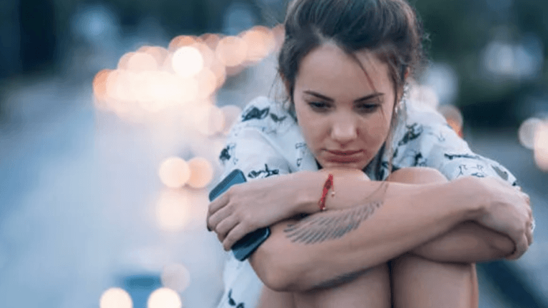 femme assise jambes dans les bras perdus dans ses pensées pour illuster Comment Belbin peut aider à répondre aux quatre facteurs du désengagement des employés